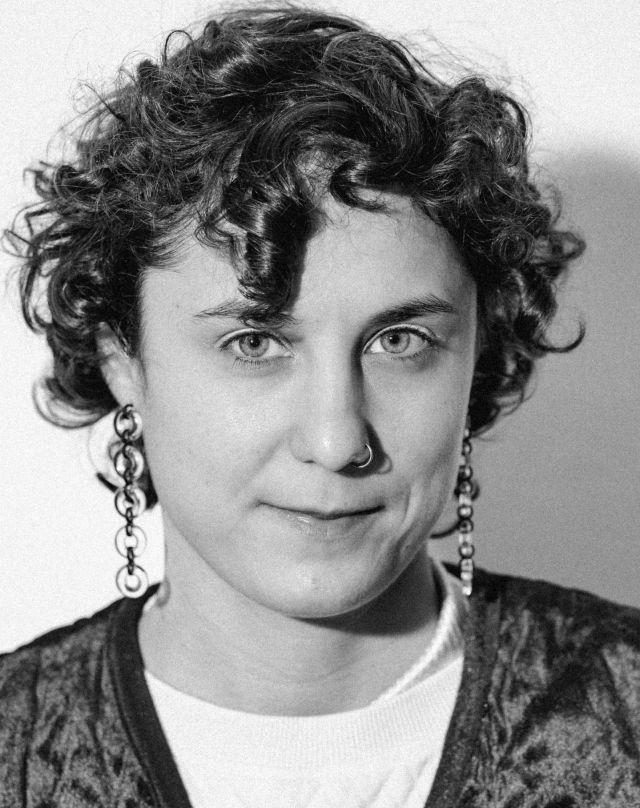 Představujeme nové umělecké vedení HaDivadla! 💥

Justina Grecová

Narodila se 8. prosince 1999 v Praze. Po gymnáziu absolvovala první ročník hebraistiky na FF UK v Praze. Dále navázala studiem dramaturgie na JAMU v Brně. Tam se stala součástí kolektivu spolu s Janou Vaverkovou a Janem Doleželem. Pohybuje se na poli mezi dramaturgií, režií a scénografií. V tvorbě se zaměřuje především na poetiku textu a performativní práci s materiálem, objektem a kostýmem. Baví ji tichý humor a opulentní vizualita.

💥 Co tě napadne jako první, když se řekne HaDivadlo?

Pořád musím myslet na dokument Autoškola sobě, kde se čtyři významní čeští divadelní režiséři snaží řídit auto, a především na to, jak Arnošt Goldflam neví, kde se odepíná bezpečnostní pás a svléká si ho přes hlavu. To je pro mě HaDivadlo a proto je tak sympatické.

💥 V čem vidíš rozdíl HaDivadla oproti jiným divadlům?

HaDivadlo vnímám příjemně introvertně, nesnaží se být větší, než je, ale pořád má svou důstojnost a váhu. ✨

💥 Jaký máš první zážitek s HaDivadlem spojený?

Prvním intenzivním zážitkem pro mě byla inscenace Prezidentky, kterými žiju dodnes, klidně bych chodila na každou reprízu a poslouchala pořád dokola všechny ty sprosťárničky.

💥 Která inscenace z minulosti HaDivadla tě opravdu silně oslovila?

Zeď, Woyzeck, Naši

💥 A nyní to hlavní – jak vidíš budoucnost HaDivadla?

Šťavnatě, k zakousnutí, někdy možná jen k ležérní degustaci – a to je taky fajn! 🍇

📷 @dag_markl